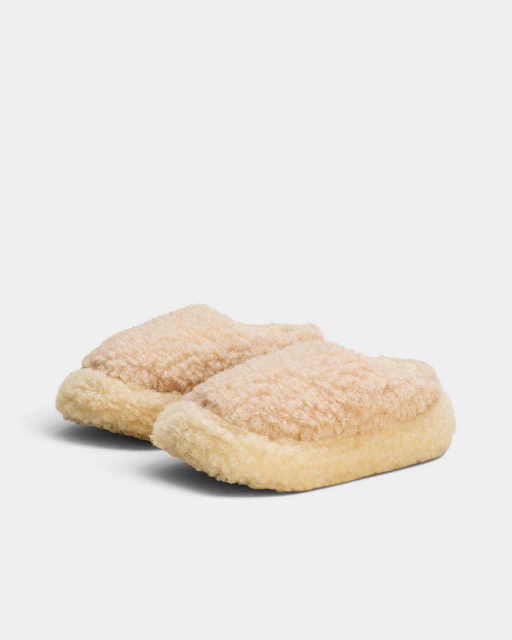A pair of Rue De Wool The Nordic Low slippers in desert brown and natural, angled side view