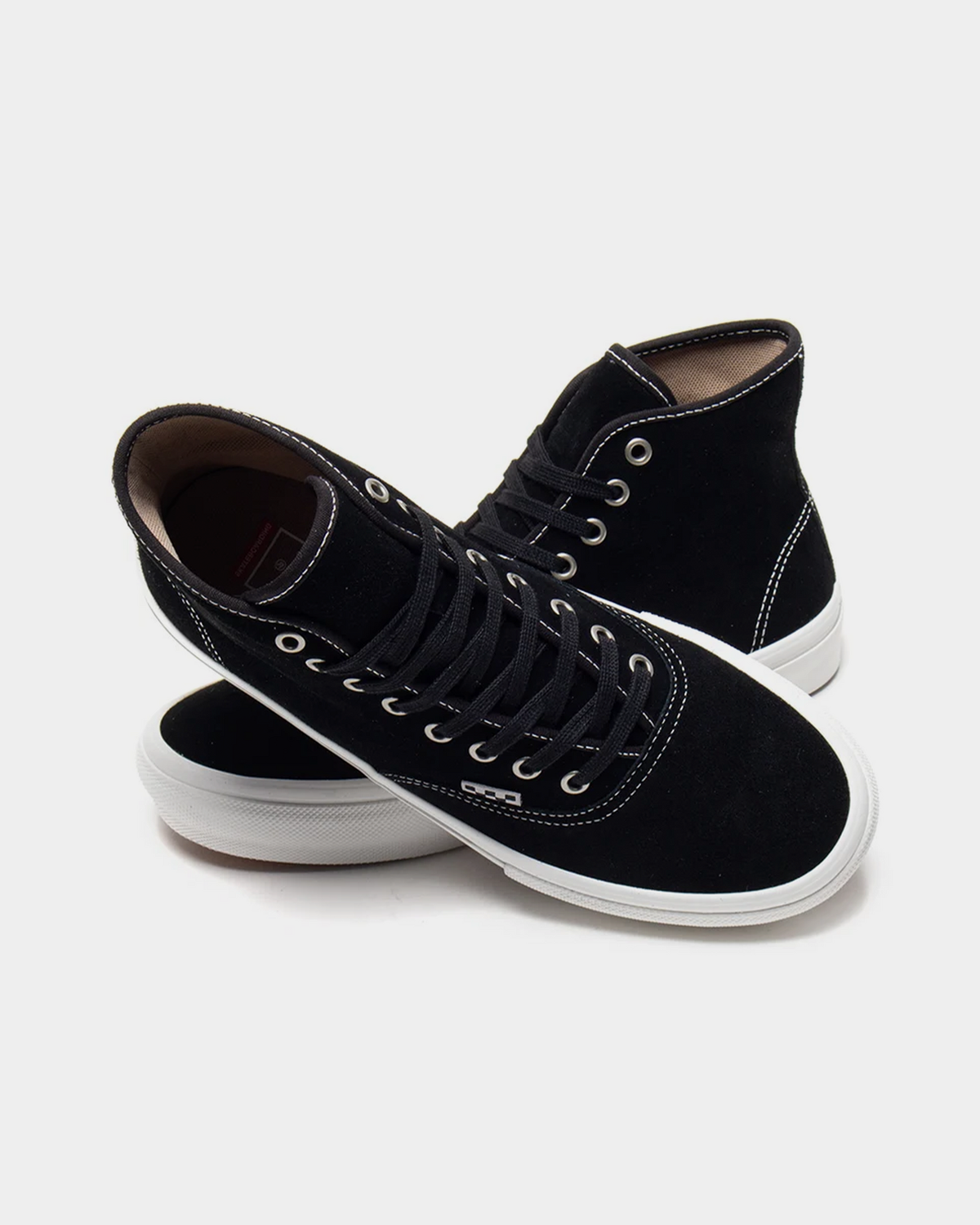 Two Vans Skate Authentic High black suede skate shoes crossed over each other, showing the lacing, padded collar and white sidewall