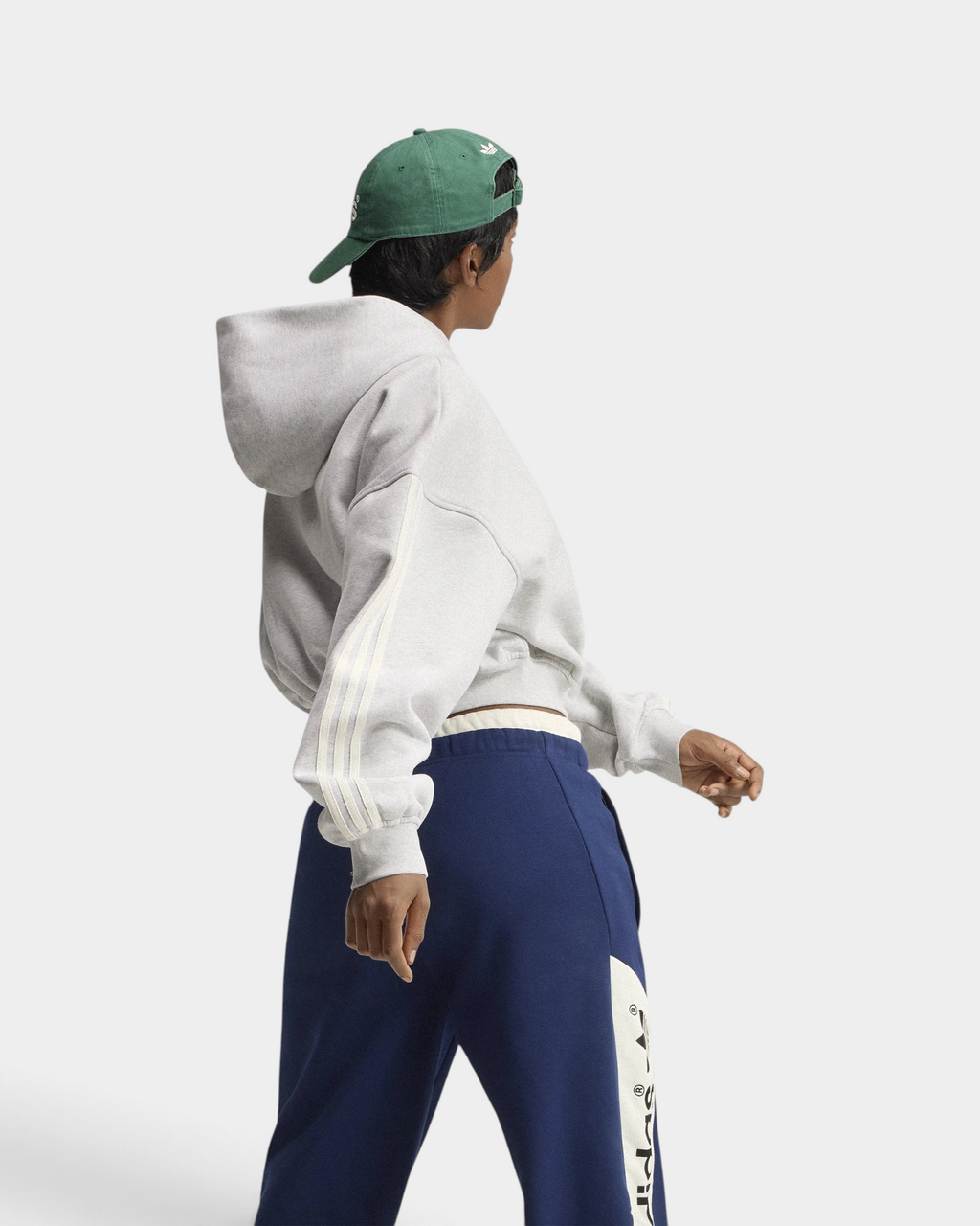 Lockwood Avenue adidas adiSignature 3-Stripes Hoodie in light grey heather, side view of the sleeve stripes and hood on a model with a green cap