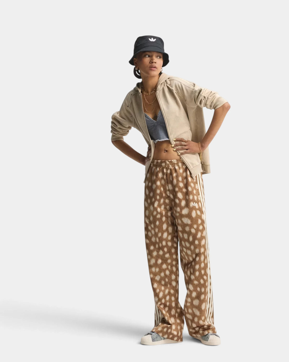 Lockwood Avenue adidas Firebird Animal Print Track Pants worn by a model standing hands on hips, with a bucket hat and a cream jacket