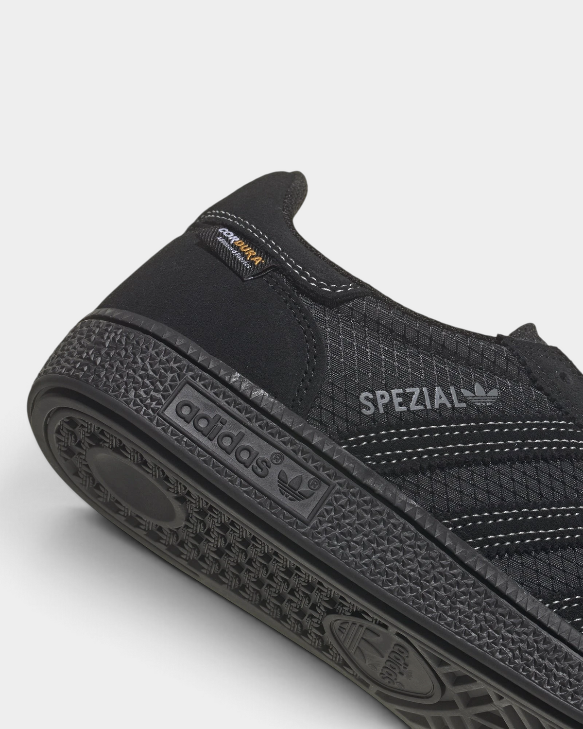 Lockwood Avenue adidas Handball Spezial shoe in all black with a CORDURA ripstop quarter and suede overlays, close up of the heel, the SPEZIAL branding and the adidas lettering on the sole edge