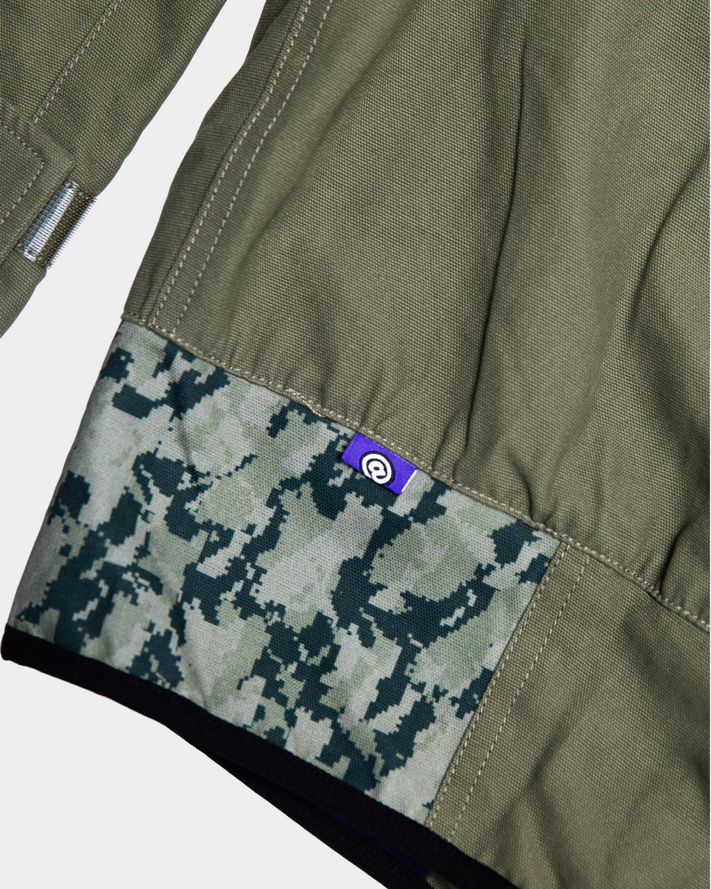 Lockwood Avenue ADWYSD NZ Digi Field Jacket in Green, close-up of the digital camo hem panel with a purple @ label
