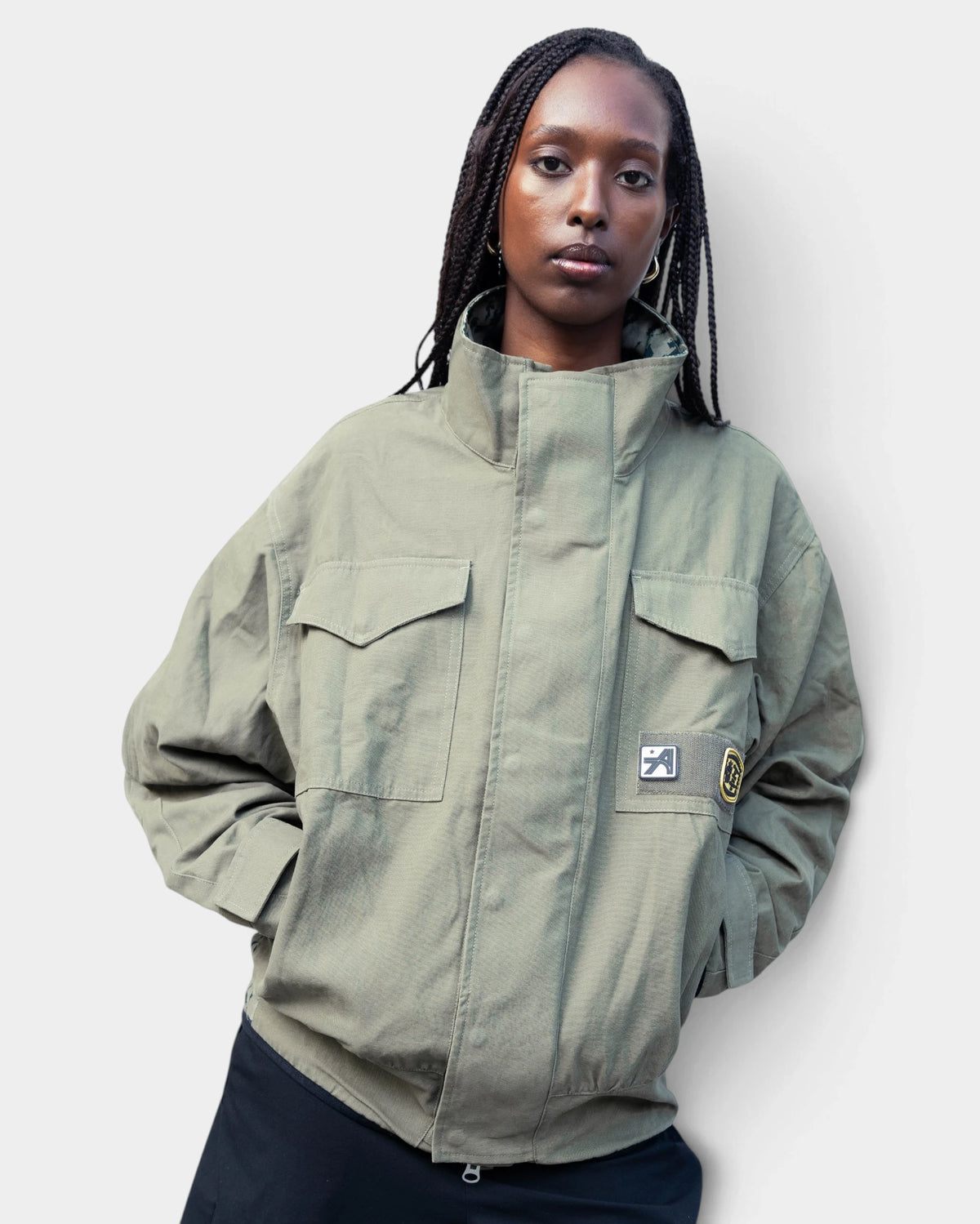 Lockwood Avenue ADWYSD NZ Digi Field Jacket in Green, worn by a model, olive jacket with flap chest pockets and a woven patch