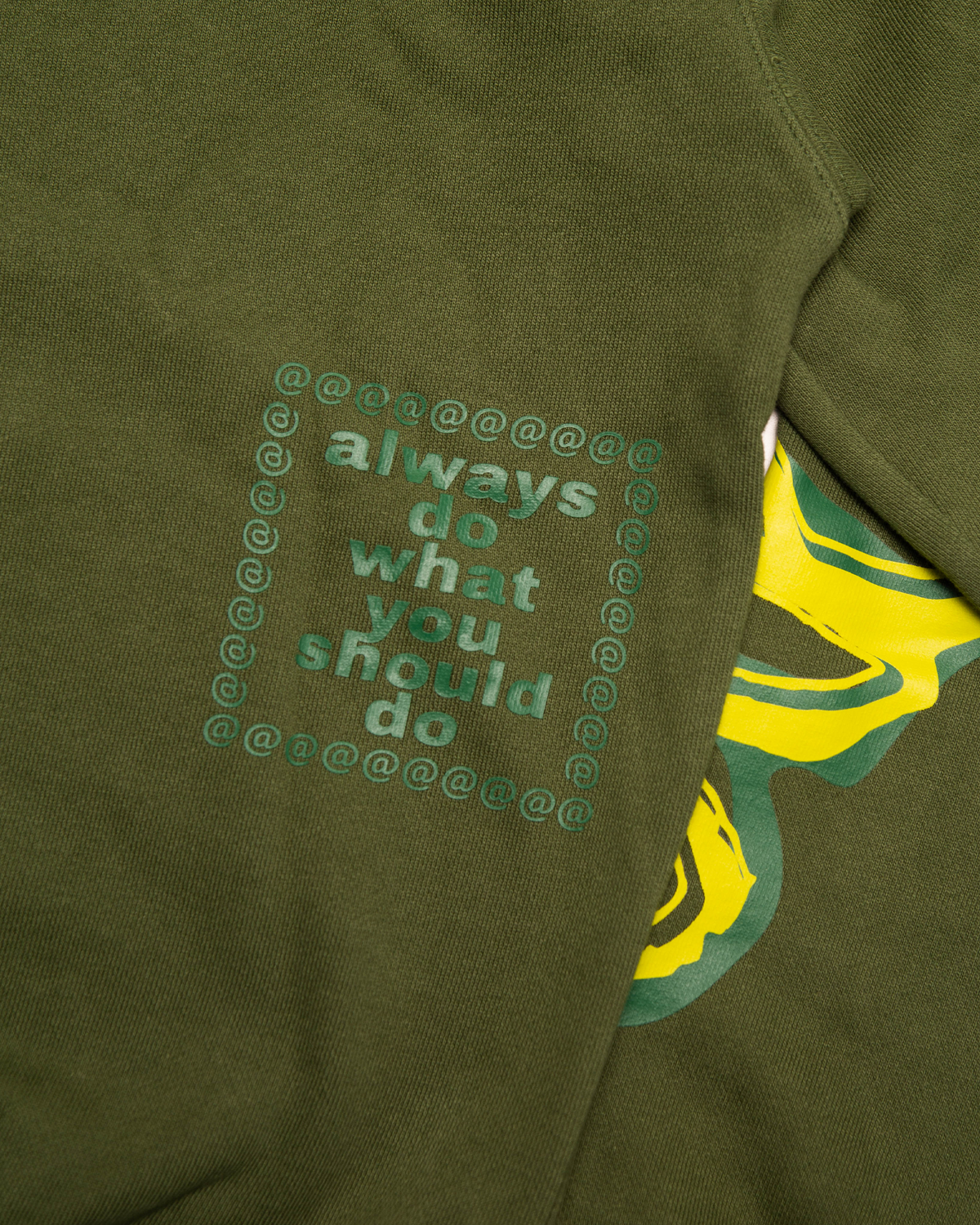 Lockwood Avenue ADWYSD Waza Hoodie in Green, close-up of the boxed always do what you should do print in tone-on-tone green beside a yellow sleeve print