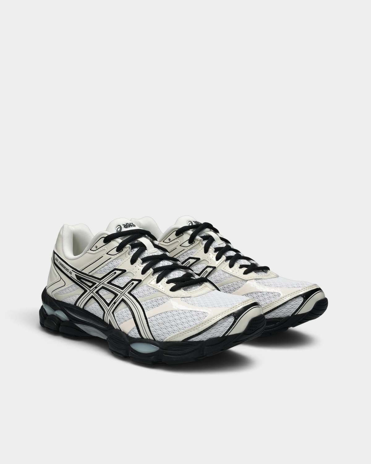 Asics GEL-Cumulus 16 Shoes in White/Cream, pair at a three-quarter front angle showing the white mesh toe box, black laces and the black sole