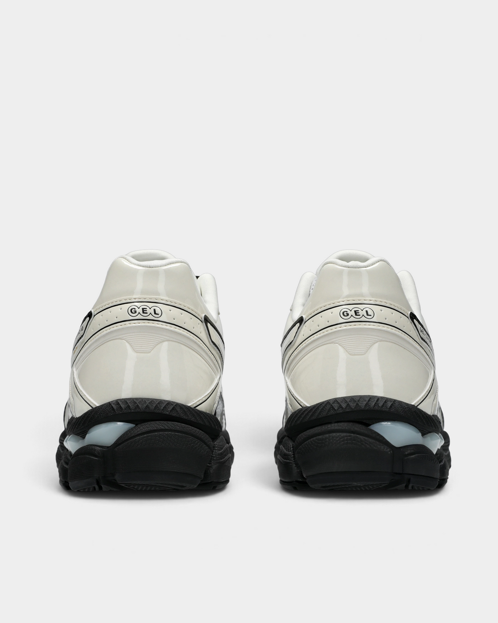 Asics GEL-Cumulus 16 Shoes in White/Cream, pair from behind: glossy cream heel counters with the GEL mark over a black midsole with clear GEL pods