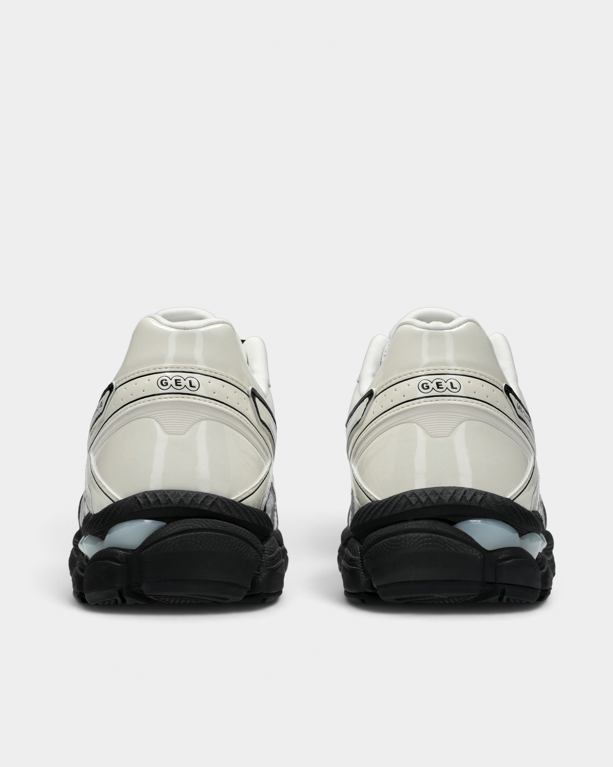 Asics GEL-Cumulus 16 Shoes in White/Cream, pair from behind: glossy cream heel counters with the GEL mark over a black midsole with clear GEL pods