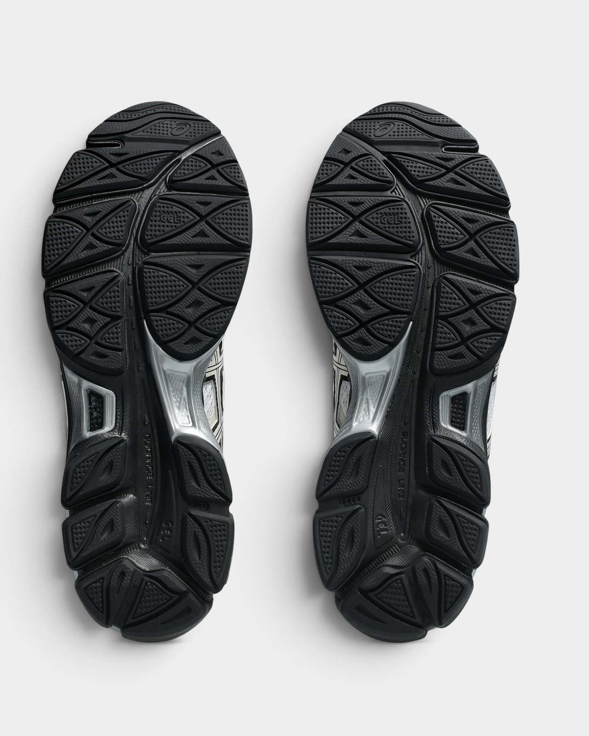 Asics GEL-Cumulus 16 Shoes in White/Cream, outsoles of the pair: black rubber with a raised tread pattern and silver-gray GEL windows at the heel