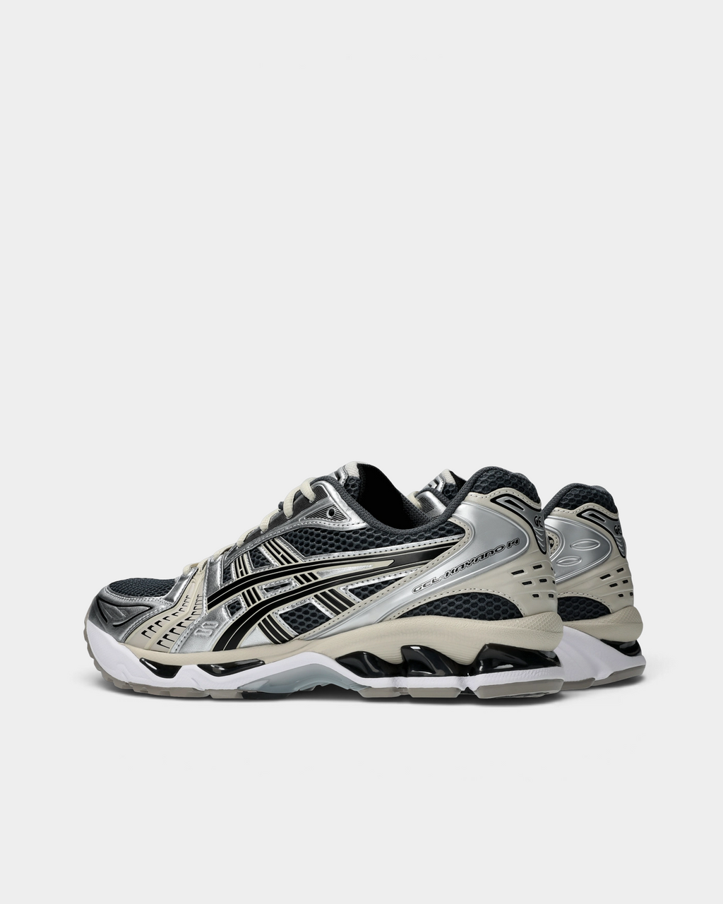Asics GEL-Kayano 14 Shoes in Carrier Grey/Black, pair from the inner side: silver heel and midfoot panels with black stripes, a cream midsole and the black GEL windows