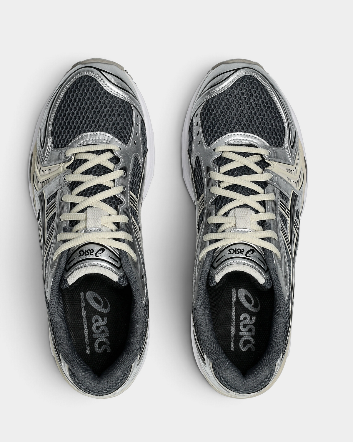 Asics GEL-Kayano 14 Shoes in Carrier Grey/Black, pair from above with cream laces over graphite mesh and silver side panels, and the ASICS logo on the insoles