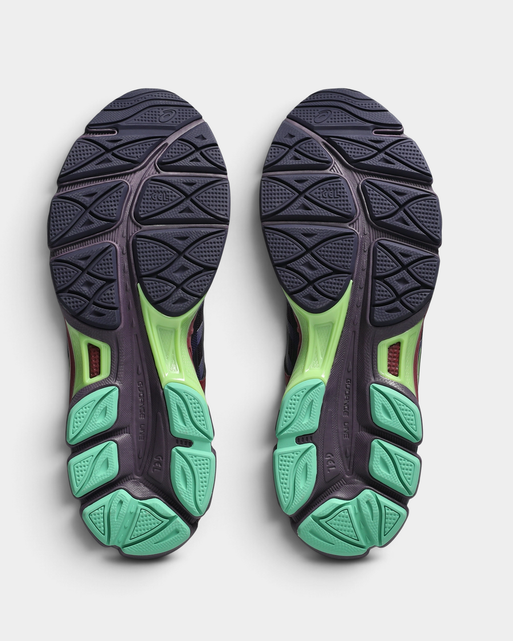 Asics US8-S GEL-SJ33 Shoes in Deep Plum/Fresh Grass, outsoles of the pair: dark grey-purple rubber with a raised tread pattern and mint-green and lime-green sections under the heel and forefoot