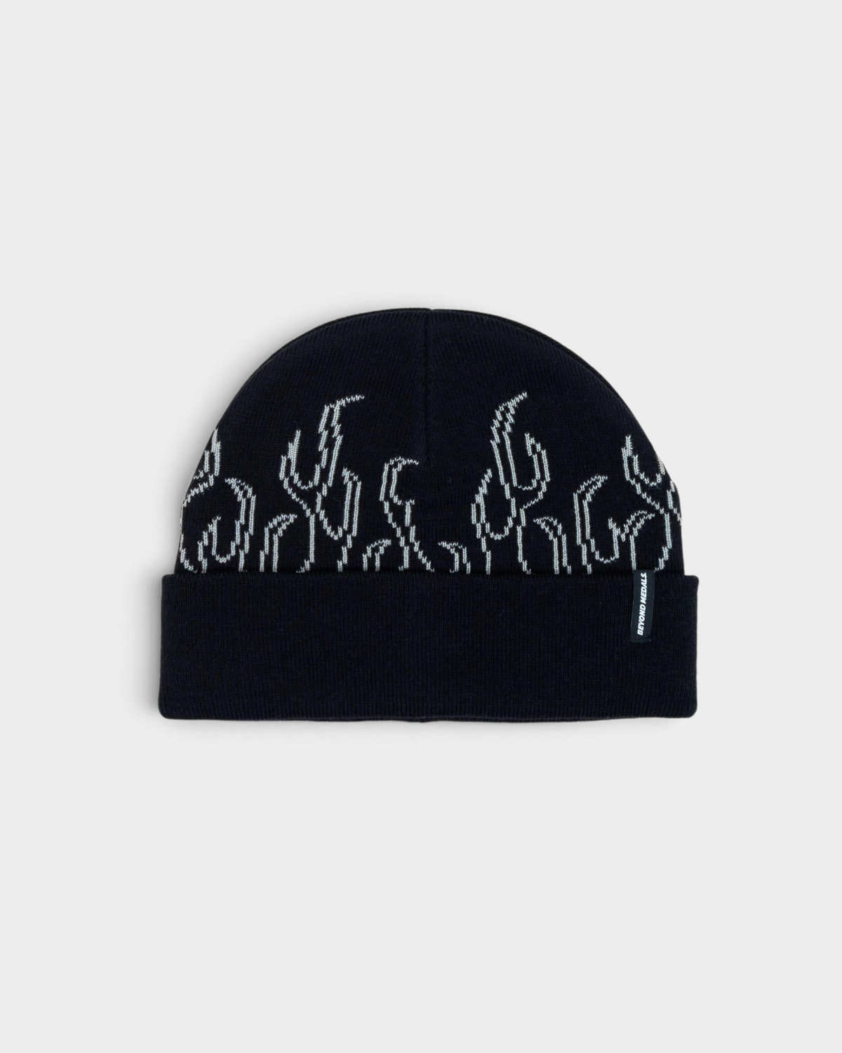 Lockwood Avenue Beyond Medals 00s Flame Beanie in black, laid flat, a folded cuff under a row of white outline flames and a small woven tab on the right side