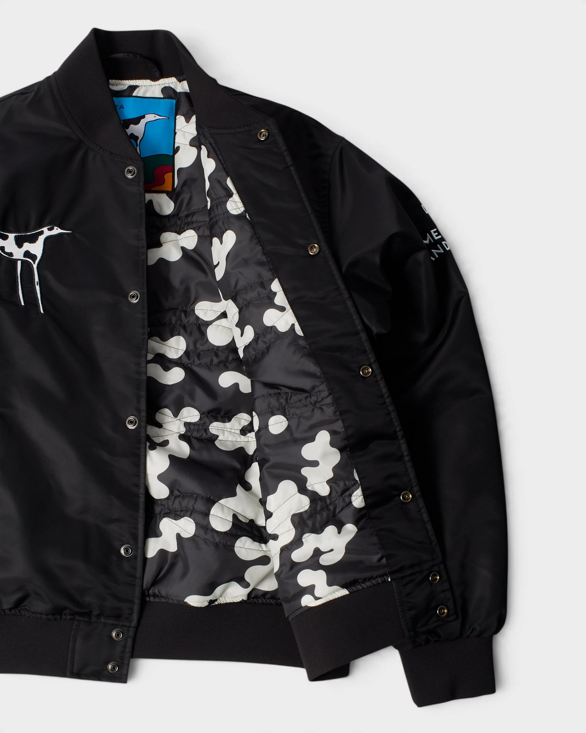by Parra Club Not 1976 Satin Bomber Jacket - Black, opened up, showing the camo print lining