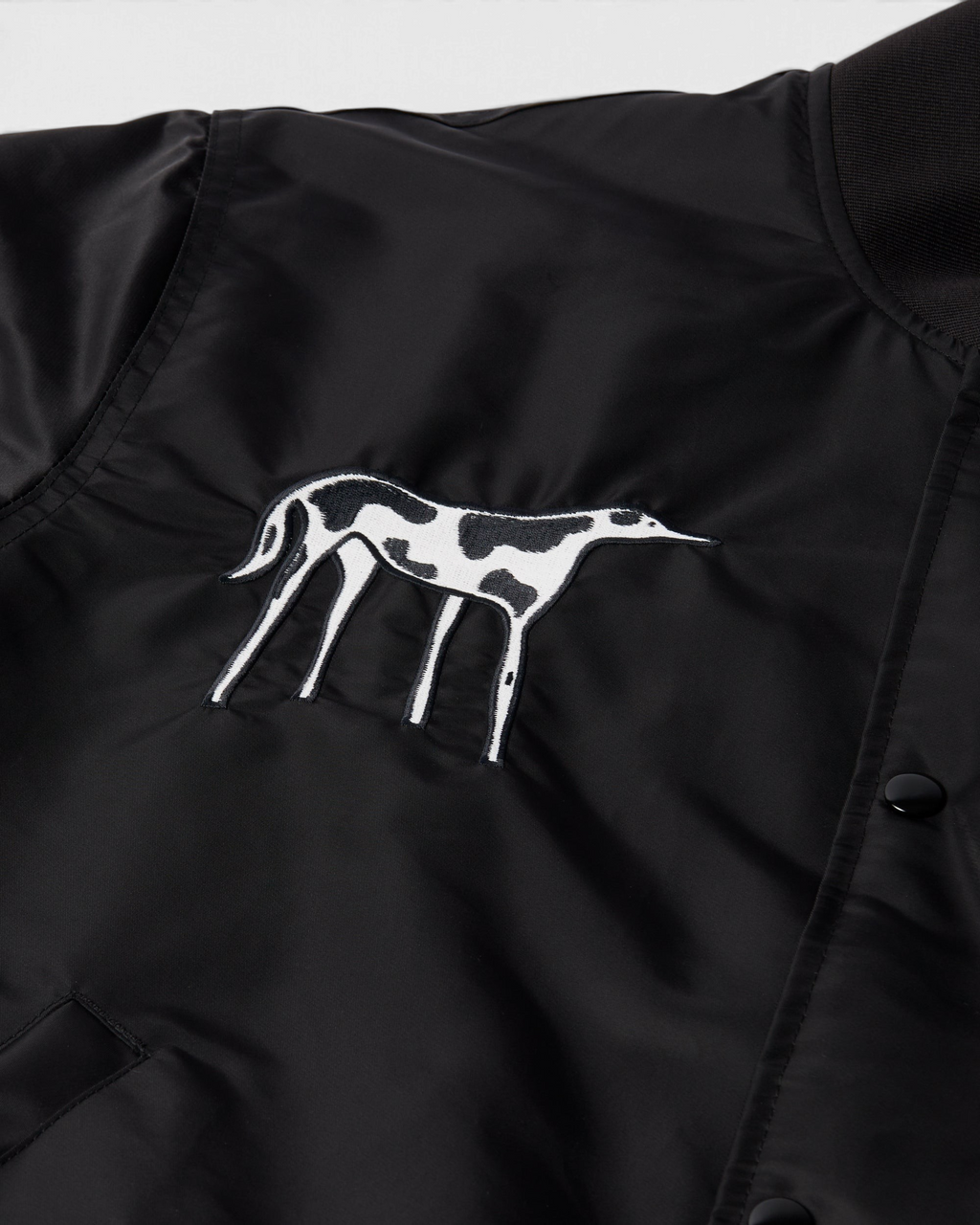 by Parra Club Not 1976 Satin Bomber Jacket - Black, close-up of the dog embroidery on the chest