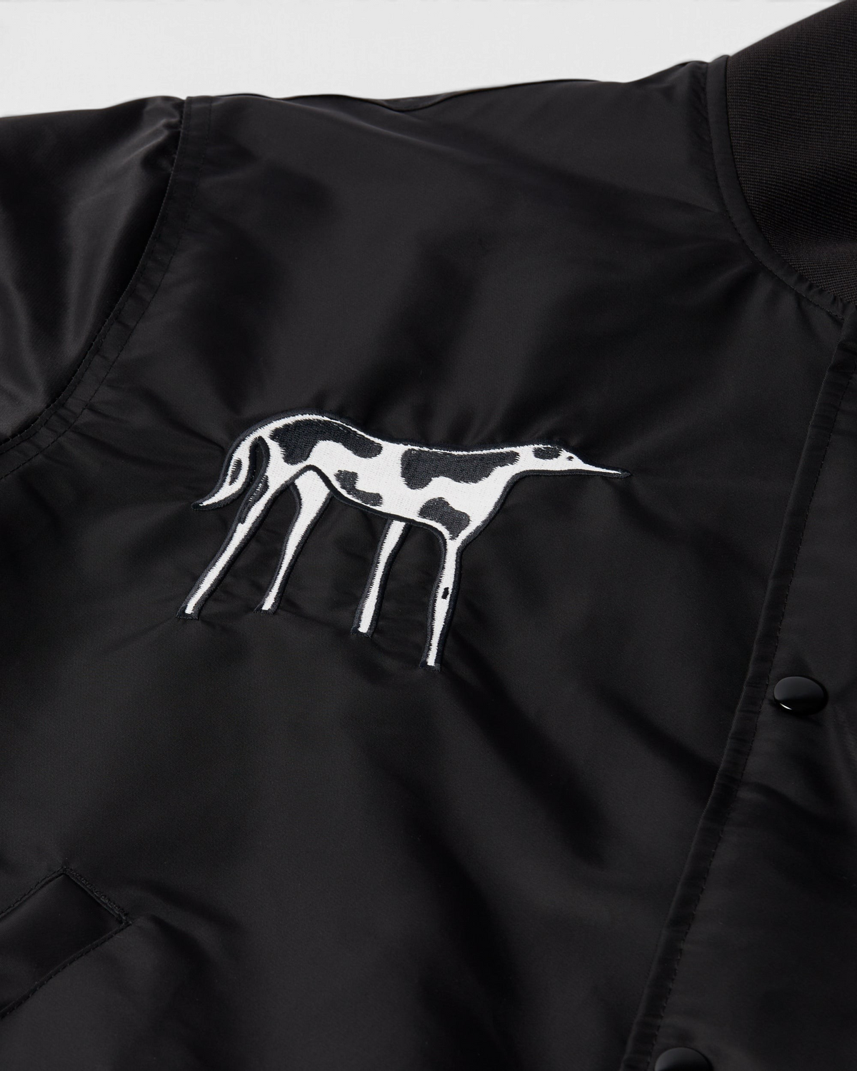 by Parra Club Not 1976 Satin Bomber Jacket - Black, close-up of the dog embroidery on the chest