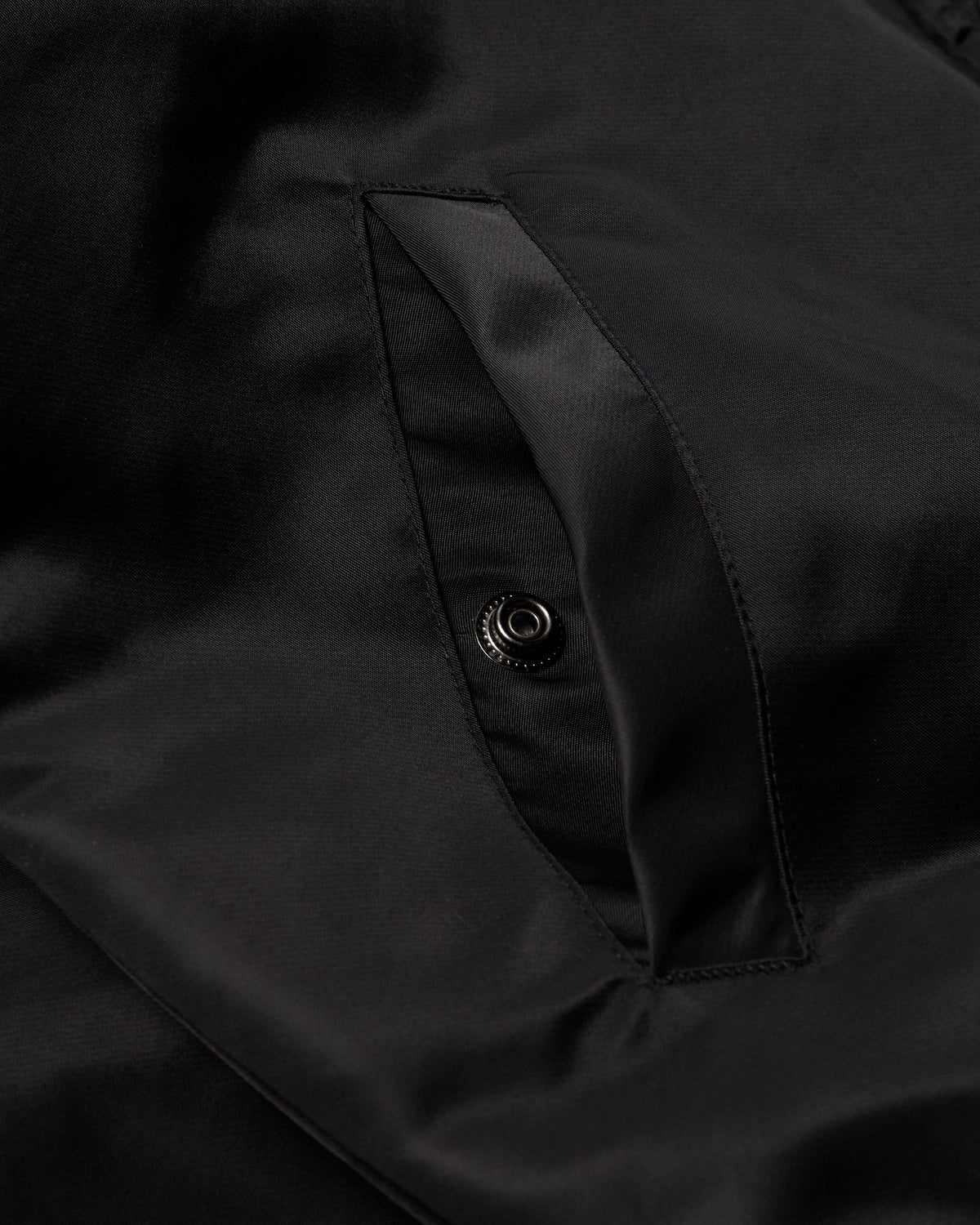 by Parra Club Not 1976 Satin Bomber Jacket - Black, close-up of a side pocket