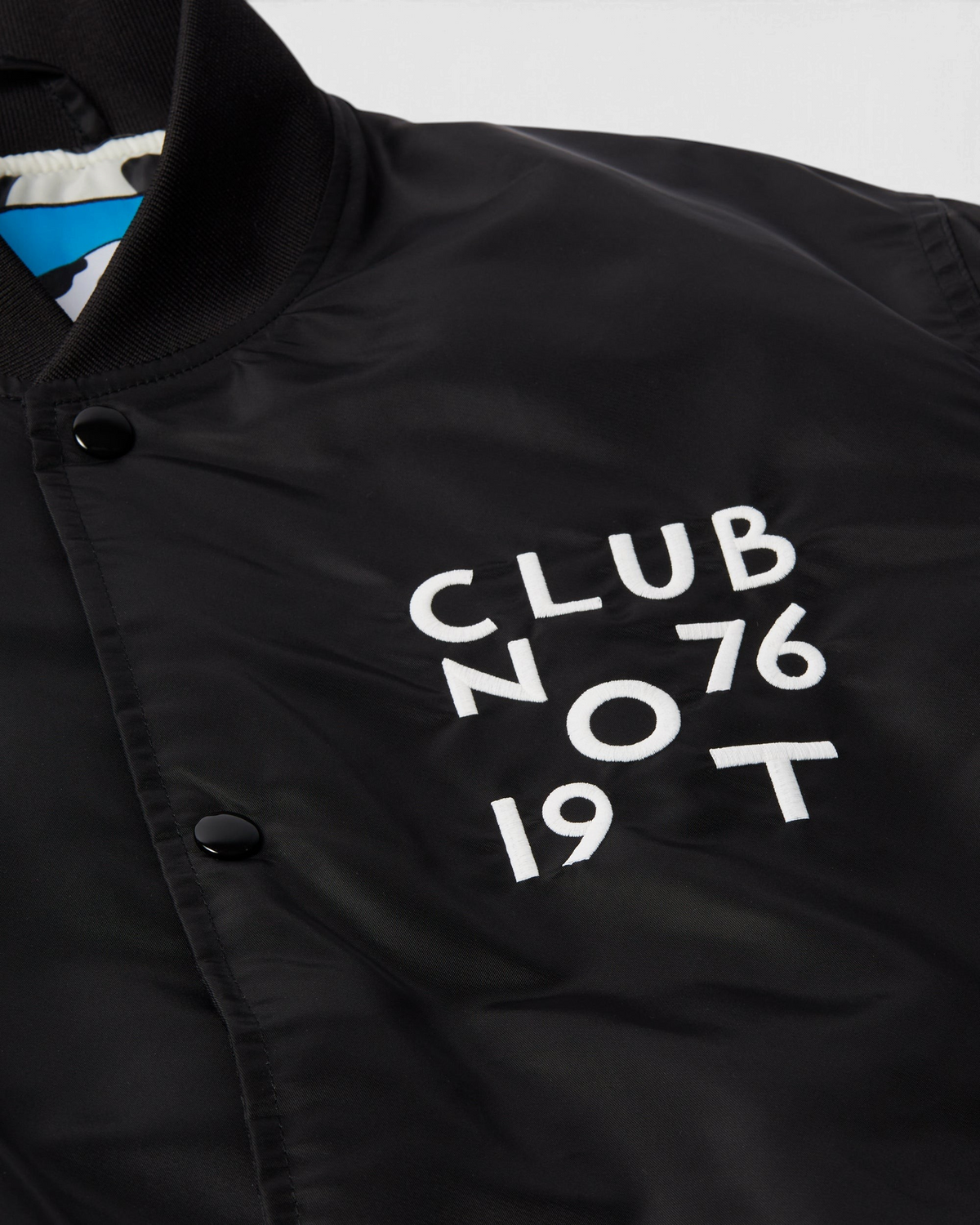 by Parra Club Not 1976 Satin Bomber Jacket - Black, close-up of the Club Not 1976 chest embroidery