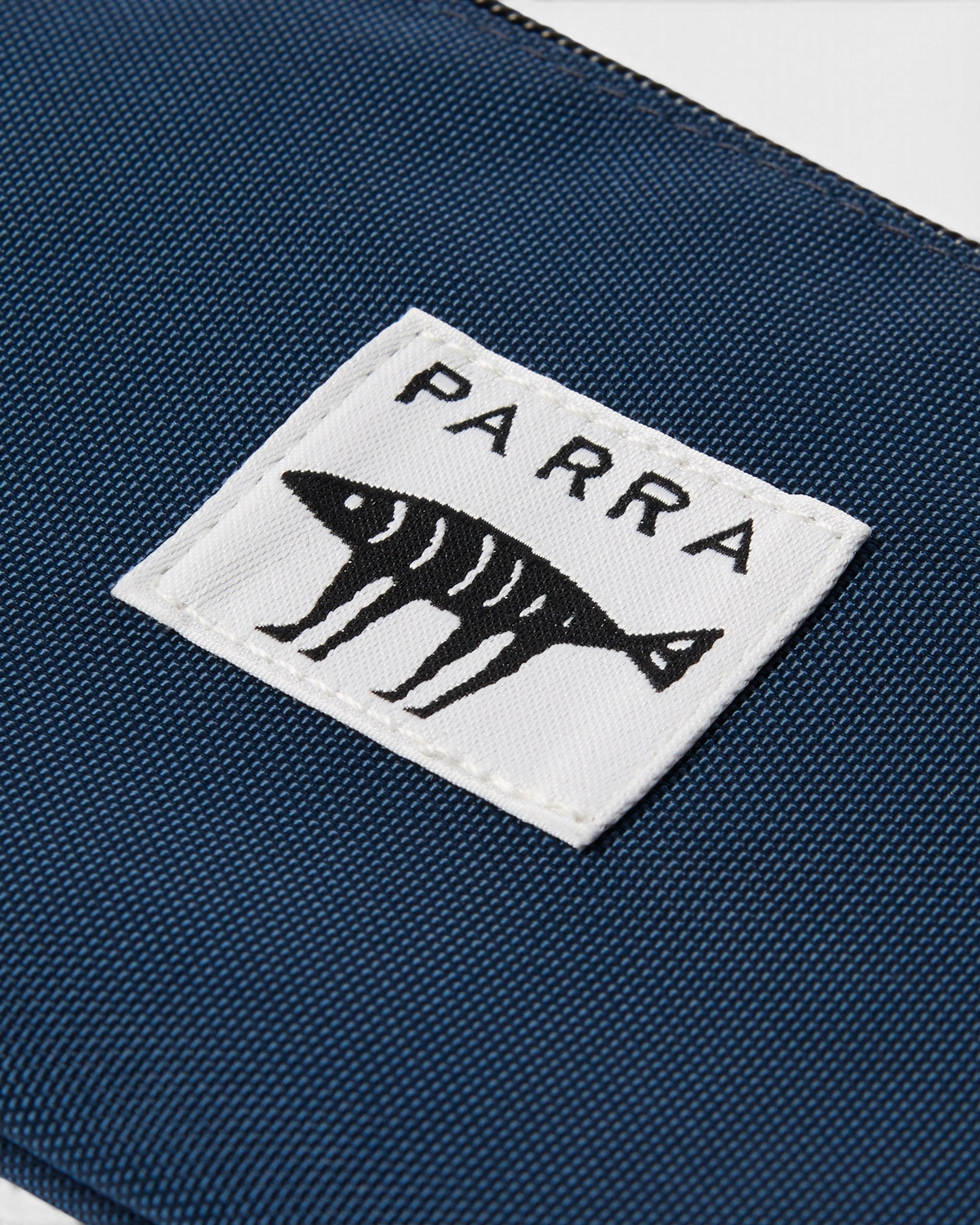 by Parra Money Darwin Pouch Wallet - Blue, close-up of the woven Parra label