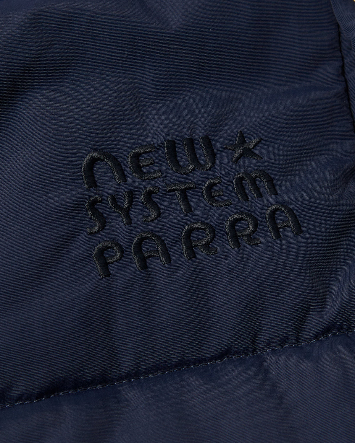 by Parra New System Puffer Vest - Navy Blue, close-up of the New System Parra chest embroidery