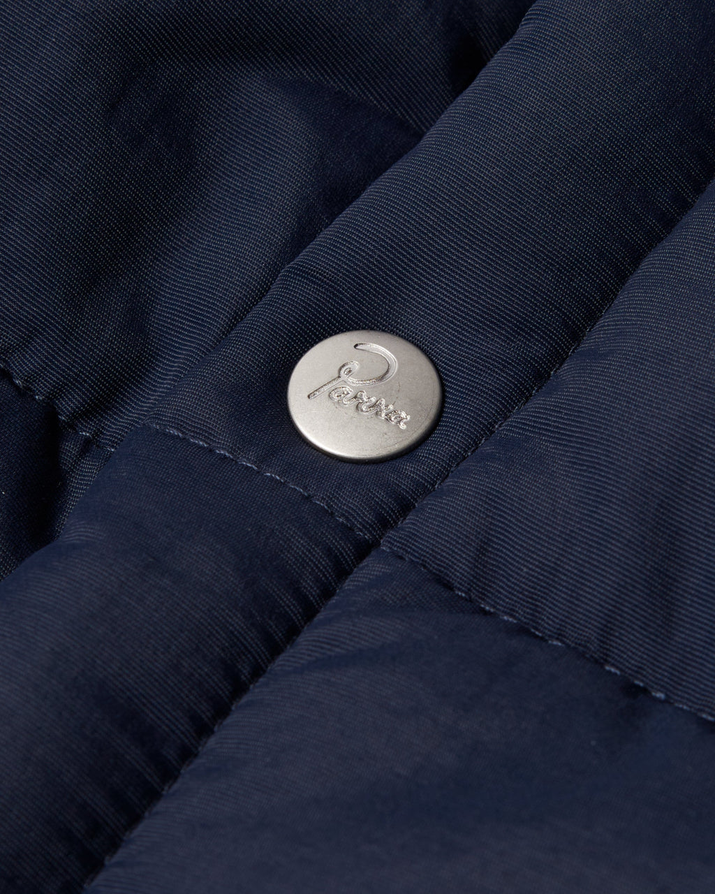 by Parra New System Puffer Vest - Navy Blue, close-up of a Parra snap button