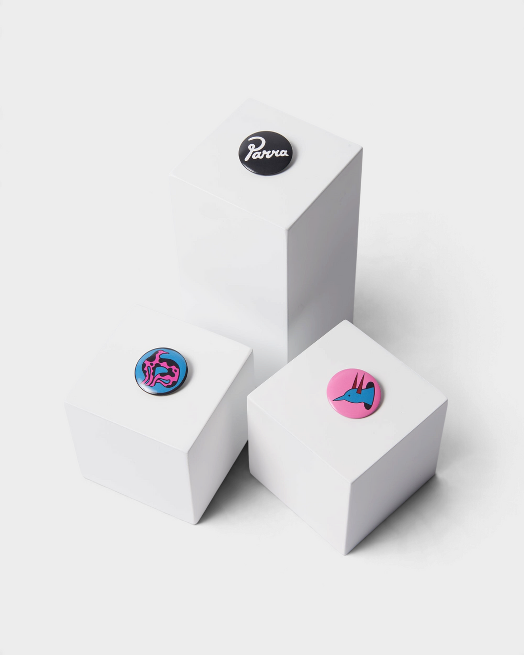 by Parra Some Butonis Pin-Back Set - Pink, the three buttons shown on white blocks