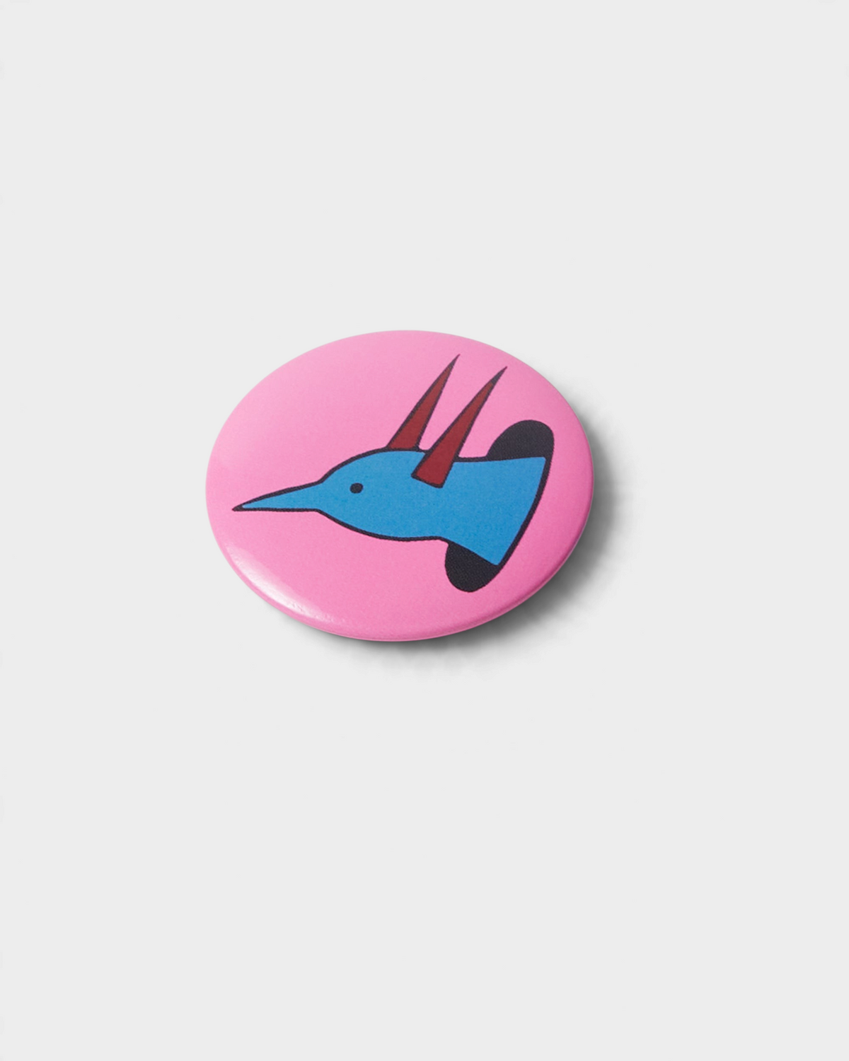 by Parra Some Butonis Pin-Back Set - Pink, close-up of the pink button with a blue horned bird