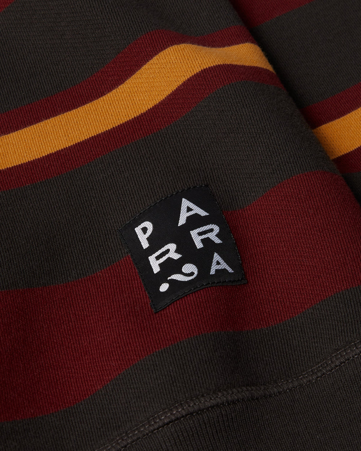 by Parra Sweatstriped Crewneck Sweatshirt - Brown, close-up of the Parra label at the hem