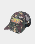 DC Shoes Fish On Cap in Classic Camo, three-quarter front view of the green and brown camo trucker showing DCSHOES embroidered in a yellow to orange gradient script, a small white 94 patch on the mesh side panel and a frayed distressed bill