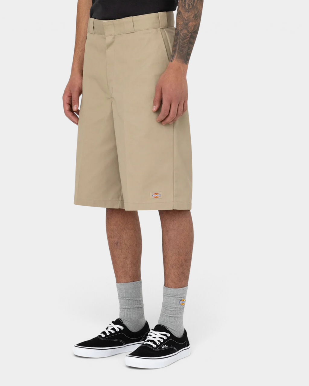Lockwood Avenue model wearing stone Dickies 13 inch work shorts, side view showing the loose fit