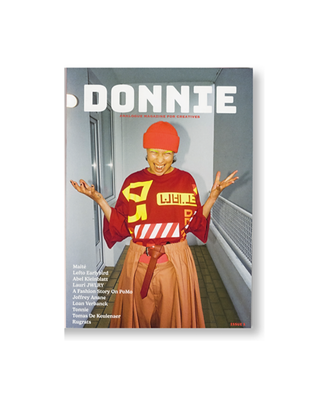 Lockwood Avenue Donnie Magazine Issue 3 cover, headline ANALOGUE MAGAZINE FOR CREATIVES, showing a laughing person in an orange beanie and red graphic top on a balcony walkway