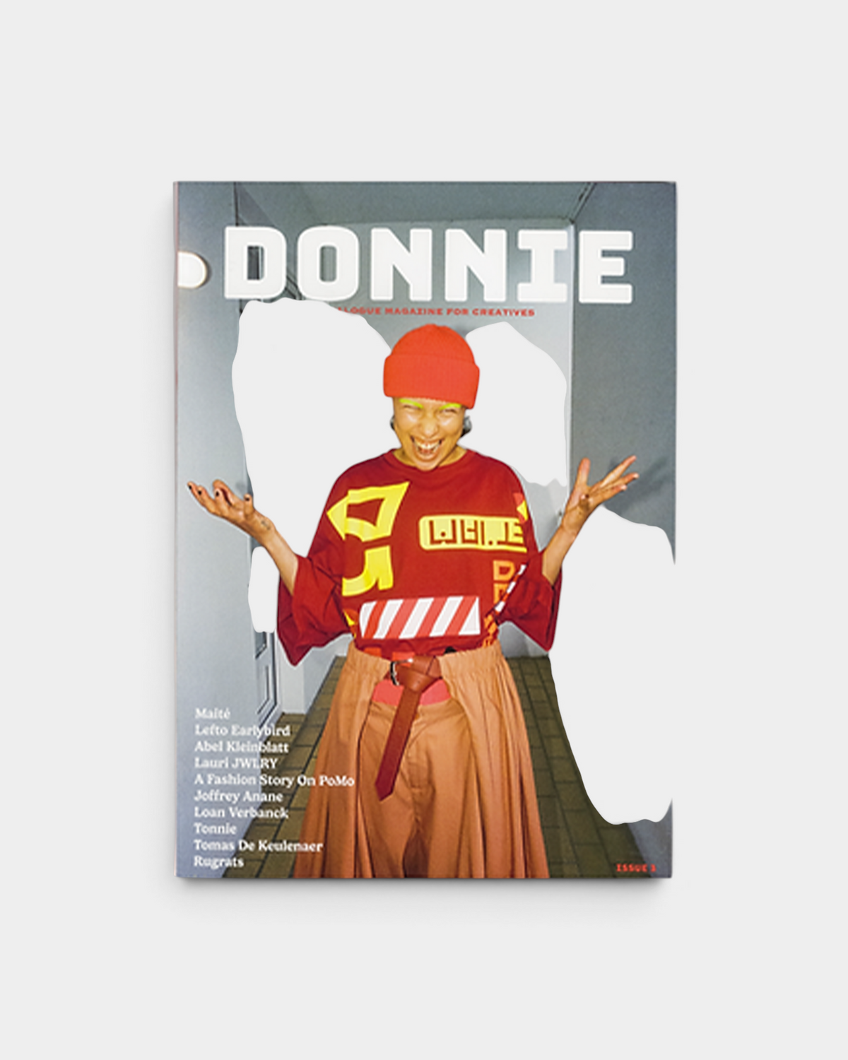 Lockwood Avenue Donnie Magazine Issue 3 cover, headline ANALOGUE MAGAZINE FOR CREATIVES, showing a laughing person in an orange beanie and red graphic top on a balcony walkway