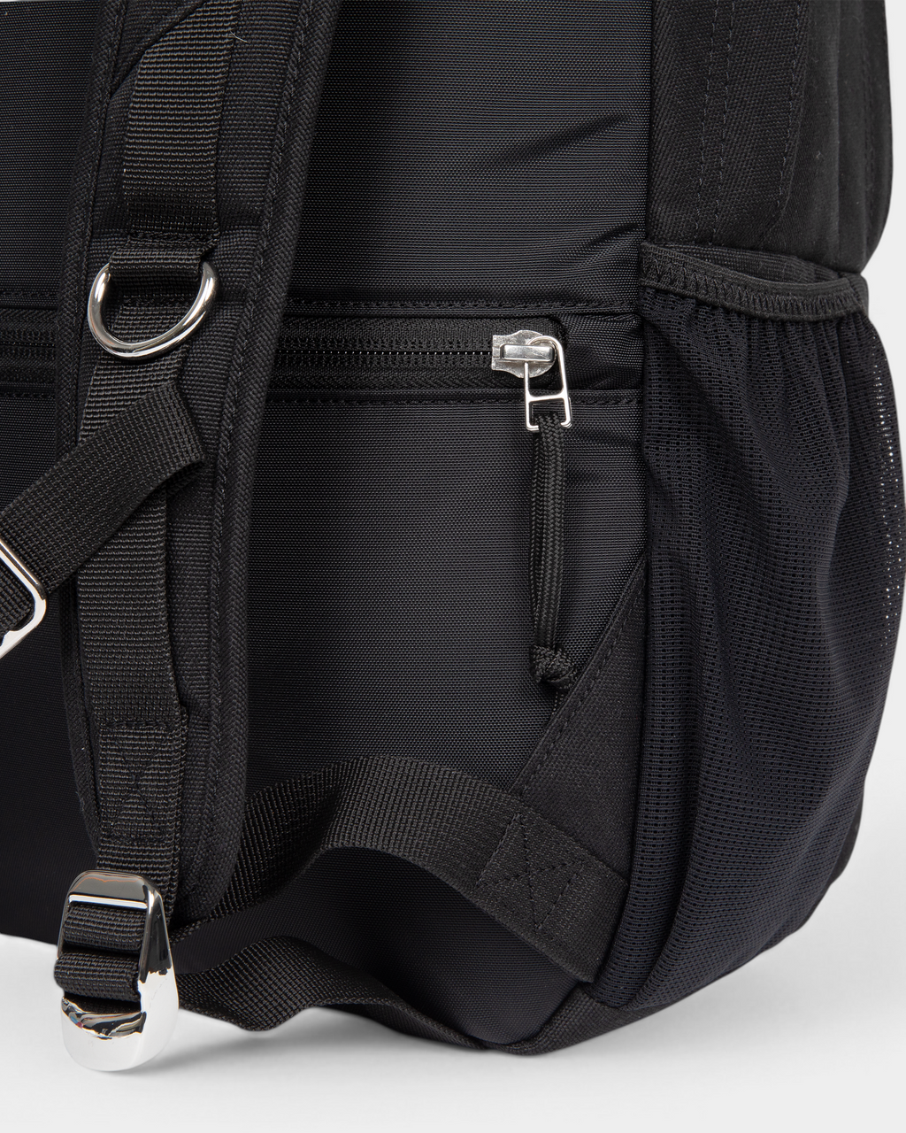 Close up of the lower side of the Eastpak x Dime Getter Backpack in Dime Black, showing the zipped side pocket and the webbing strap running into the mesh pocket