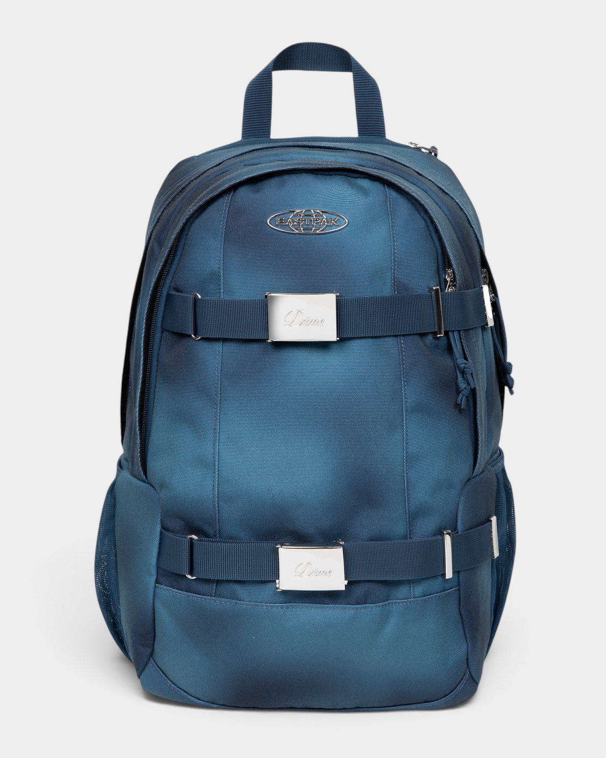 Eastpak x Dime Getter Backpack in Dime Navy, front view of the sprayed navy fade canvas pack showing the chrome Eastpak globe badge and two webbing straps with engraved Dime buckle plates