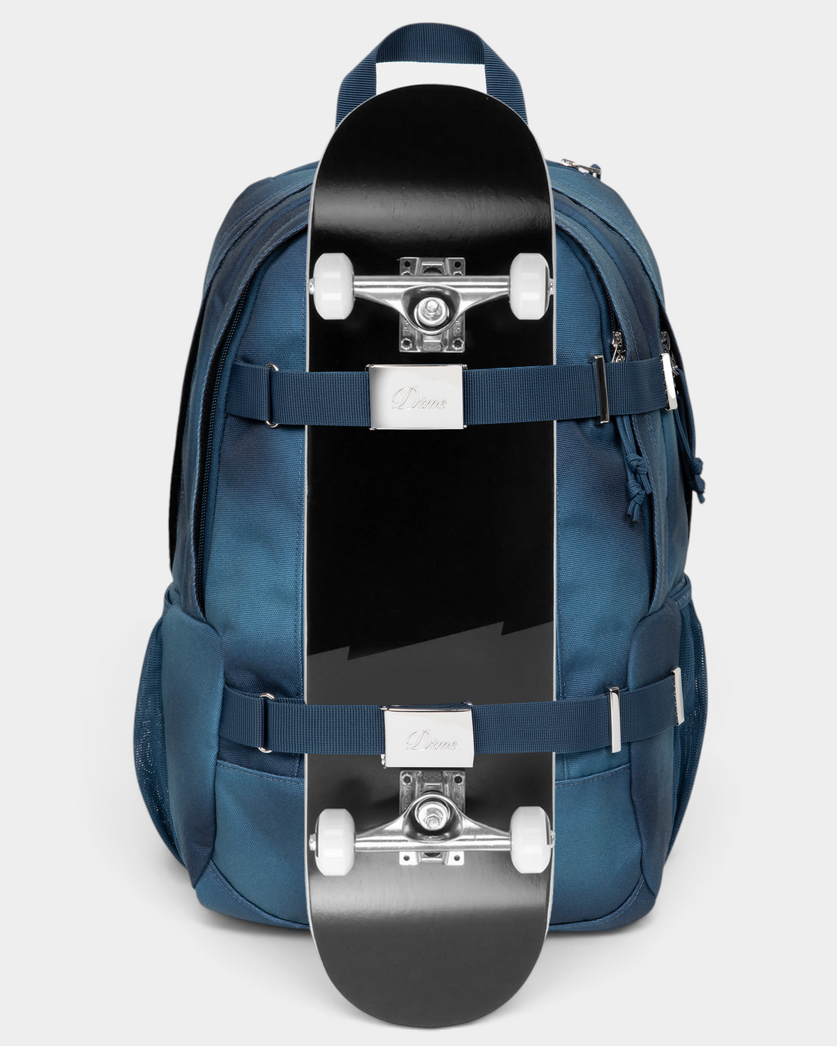 Eastpak x Dime Getter Backpack in Dime Navy with a skateboard strapped to the front under both webbing straps, showing how the board carry works
