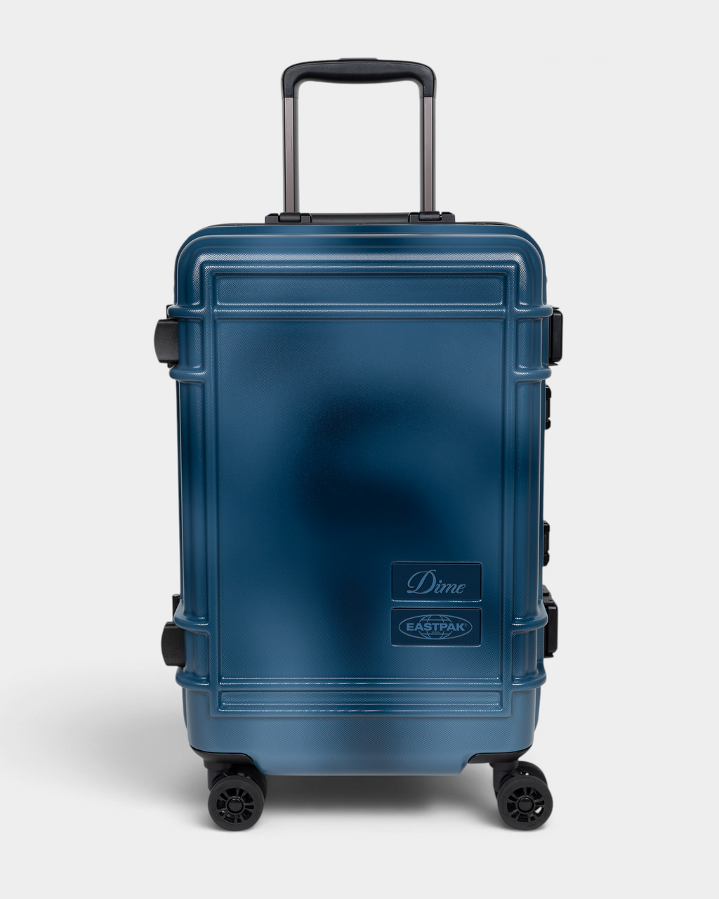 Eastpak x Dime Resist'R Case S in Dime Navy, front view of the navy hardshell cabin suitcase with its telescopic handle extended, four spinner wheels and the Dime and Eastpak badges on the lower right of the front panel