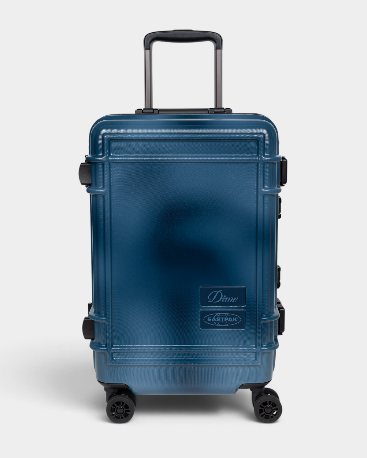 Eastpak x Dime Resist'R Case S in Dime Navy, front view of the navy hardshell cabin suitcase with its telescopic handle extended, four spinner wheels and the Dime and Eastpak badges on the lower right of the front panel