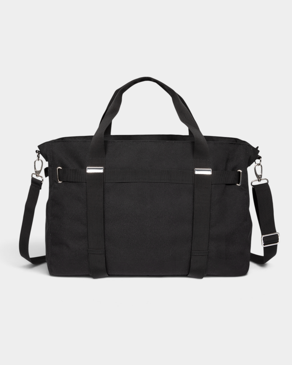 Eastpak x Dime Skate Tote in Dime Black, back view showing the plain canvas back panel, the twin webbing carry handles running down it and the adjustable shoulder strap