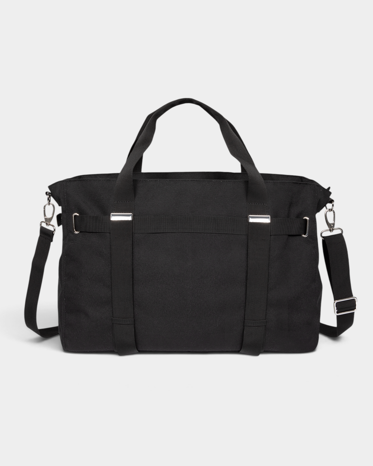 Eastpak x Dime Skate Tote in Dime Black, back view showing the plain canvas back panel, the twin webbing carry handles running down it and the adjustable shoulder strap