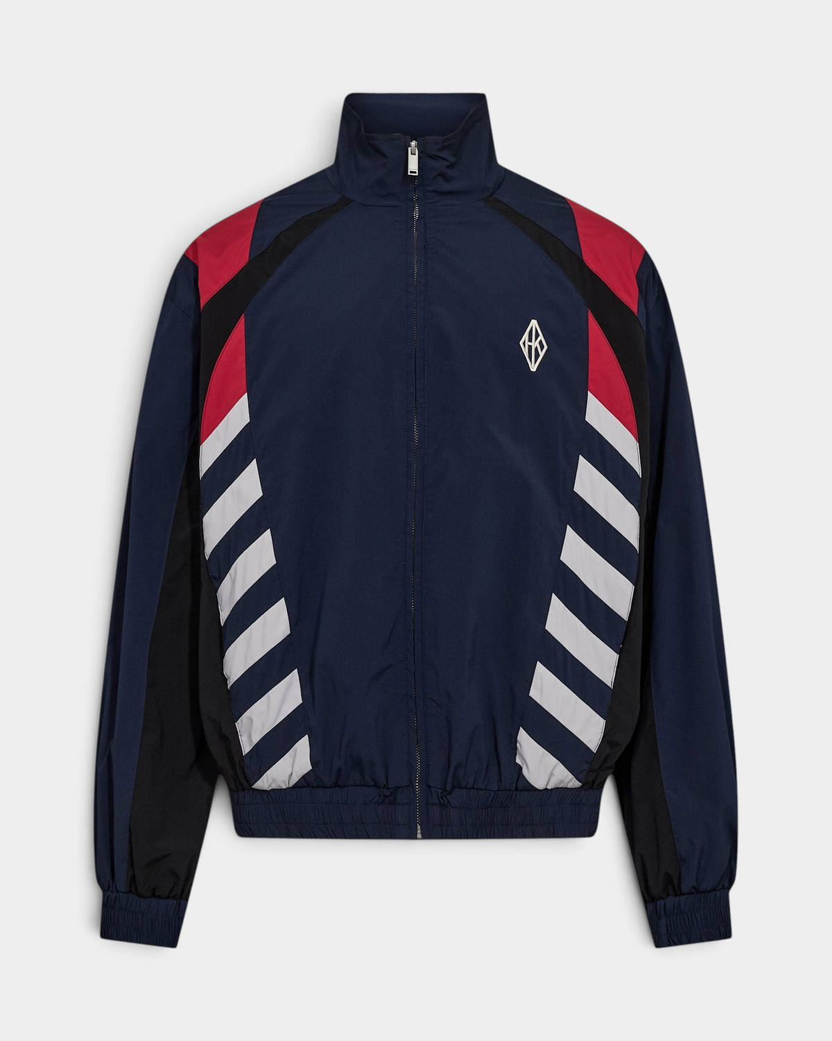 Han Kjøbenhavn Retro Track Jacket in Midnight Navy laid flat from the front, showing the funnel collar and full zip, red and black shoulder panels, grey diagonal stripe blocks at the sides and the white diamond logo at the chest