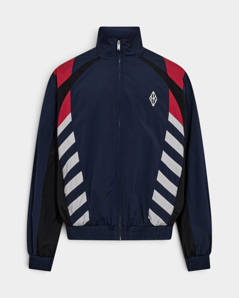Han Kjøbenhavn Retro Track Jacket in Midnight Navy laid flat from the front, showing the funnel collar and full zip, red and black shoulder panels, grey diagonal stripe blocks at the sides and the white diamond logo at the chest