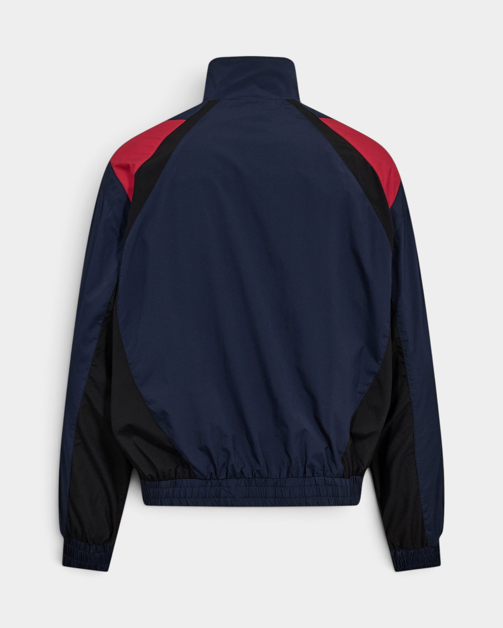 Han Kjøbenhavn Retro Track Jacket in Midnight Navy laid flat from the back, showing the red and black colour-blocked shoulder panels and the elasticated hem