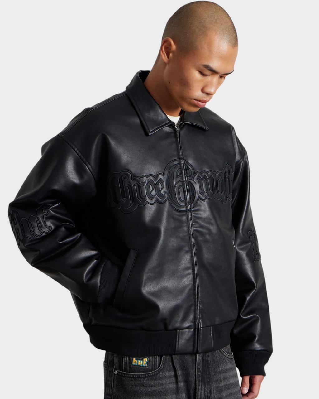 HUF x Three 6 Mafia Jacket - Black, worn by a model, three-quarter view with a hand in the pocket