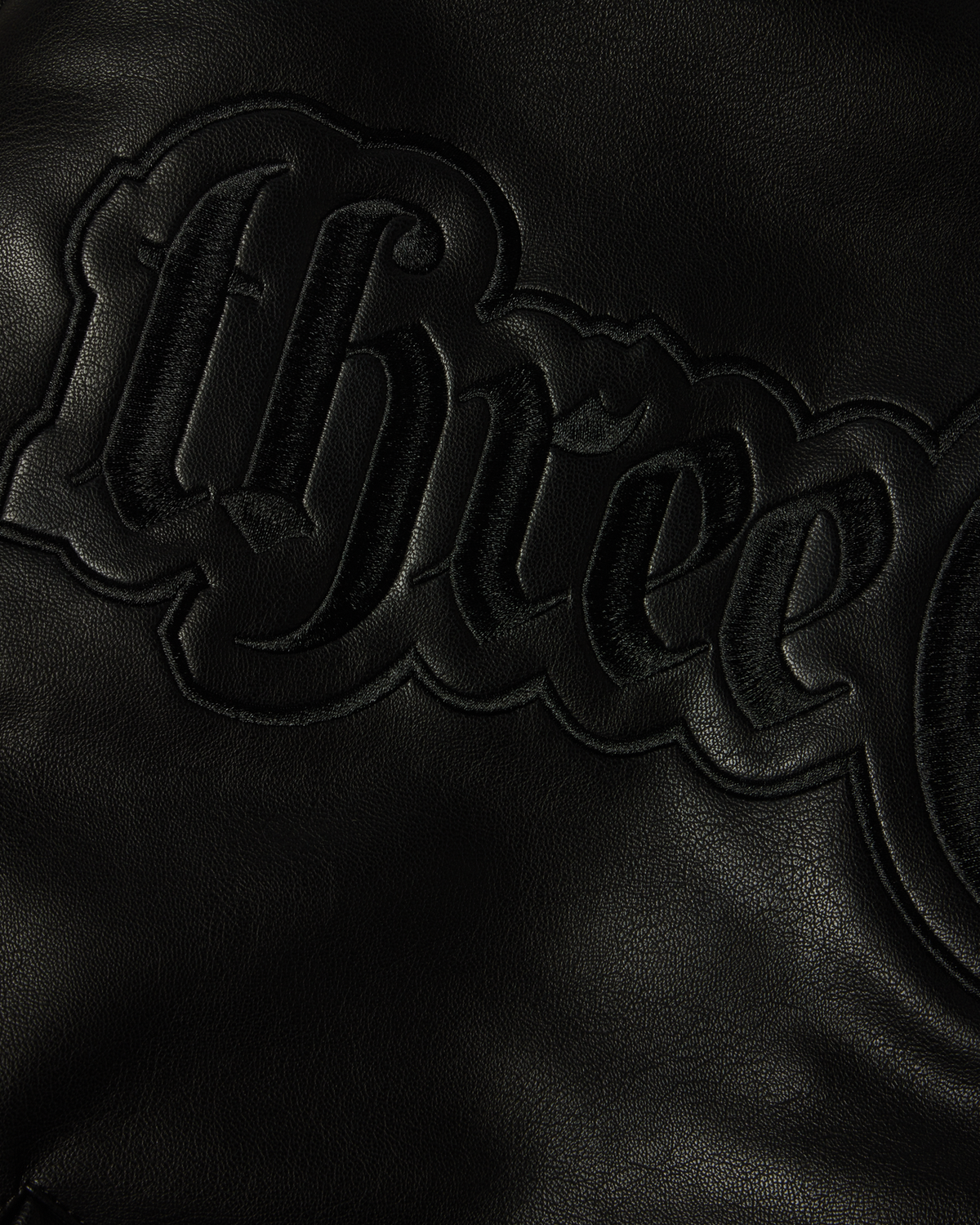 HUF x Three 6 Mafia Jacket - Black, close-up of the embossed three 6 mafia lettering