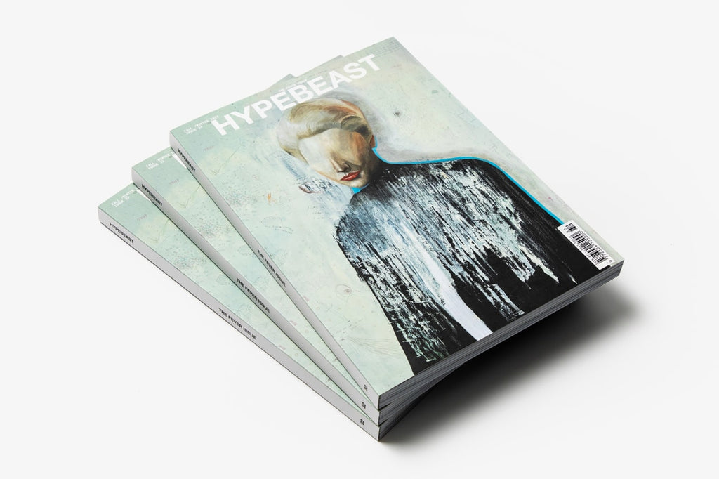 Hypebeast Magazine Issue 32, The Fever Issue, a fanned stack of copies on white showing the Jun Takahashi cover painting of a pale downturned face against black brushstrokes