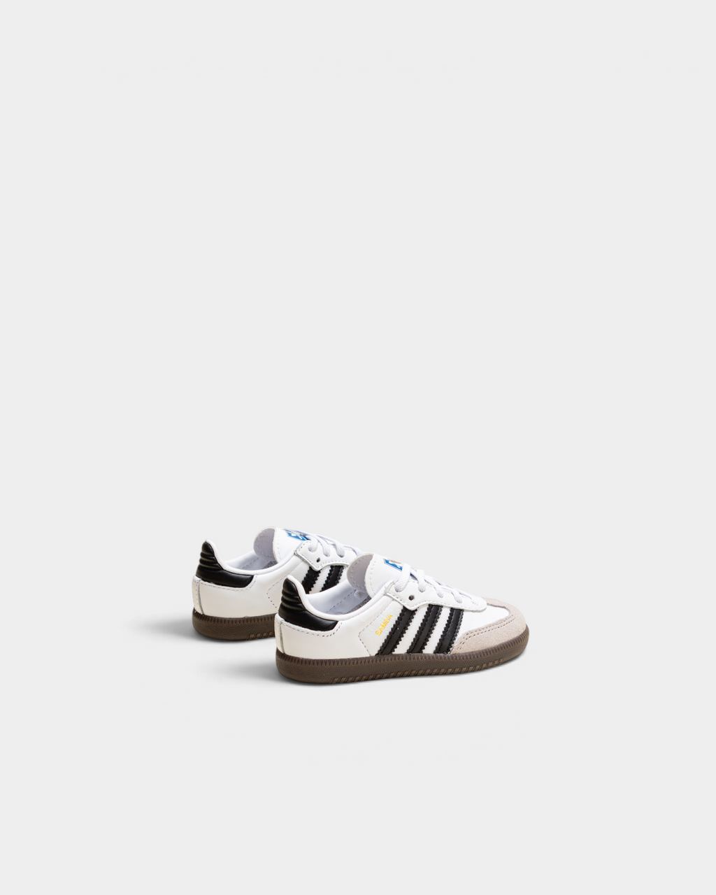 Pair of adidas Kids Samba OG shoes in cloud white, rear three-quarter view showing the black heel tab