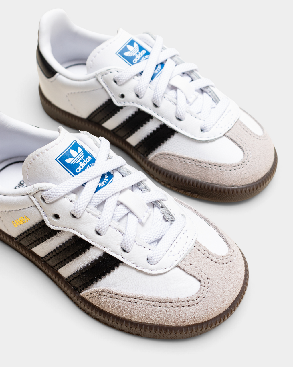 Close-up of the adidas Kids Samba OG toe box, elastic laces and blue trefoil tongue label