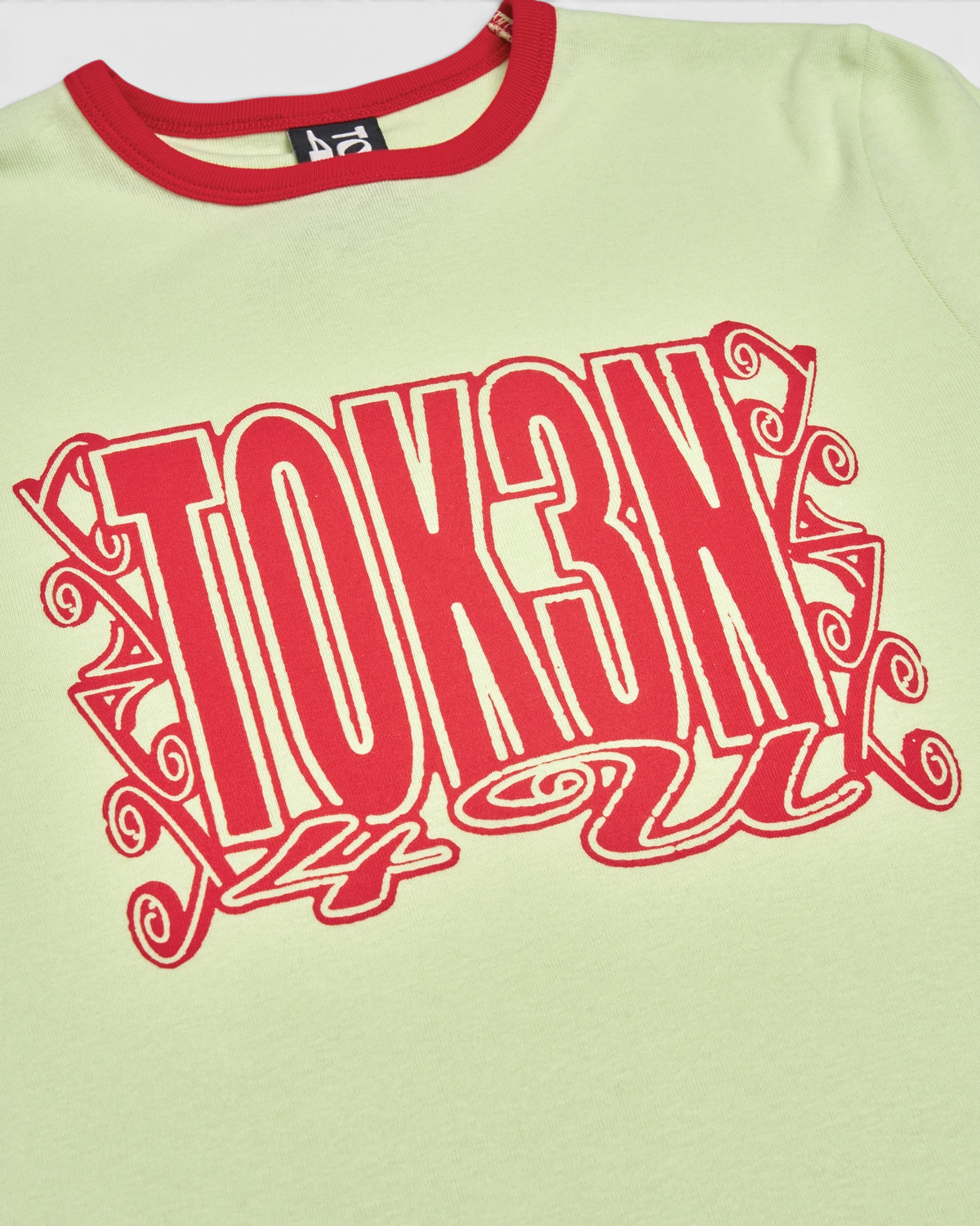 Lockwood Avenue Token Grand Unisex Ringer t-shirt in pale lime with red ribbing and red TOK3N 4 U lettering, close up of the red print and the red ribbed collar