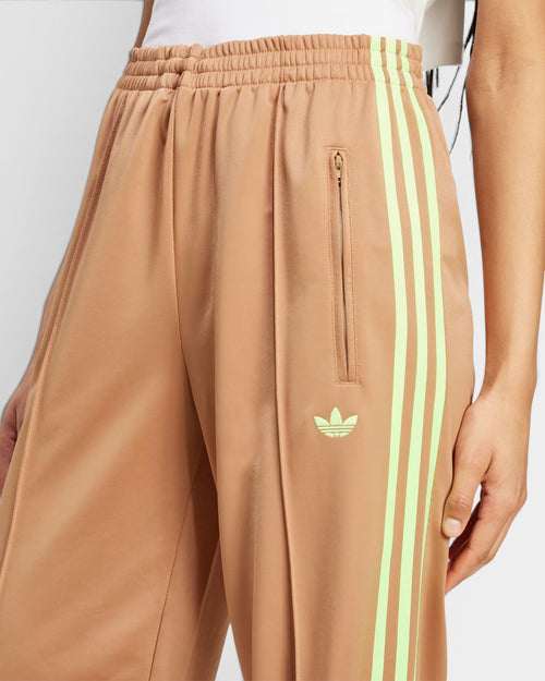 Lockwood Avenue adidas Adicolor Firebird loose track pants in beige with signal green 3-Stripes and zip pockets.