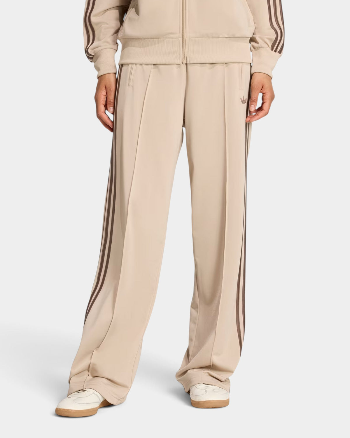 Lockwood Avenue adidas Firebird loose track pants in beige tricot with signature 3-Stripes and zippered pockets.