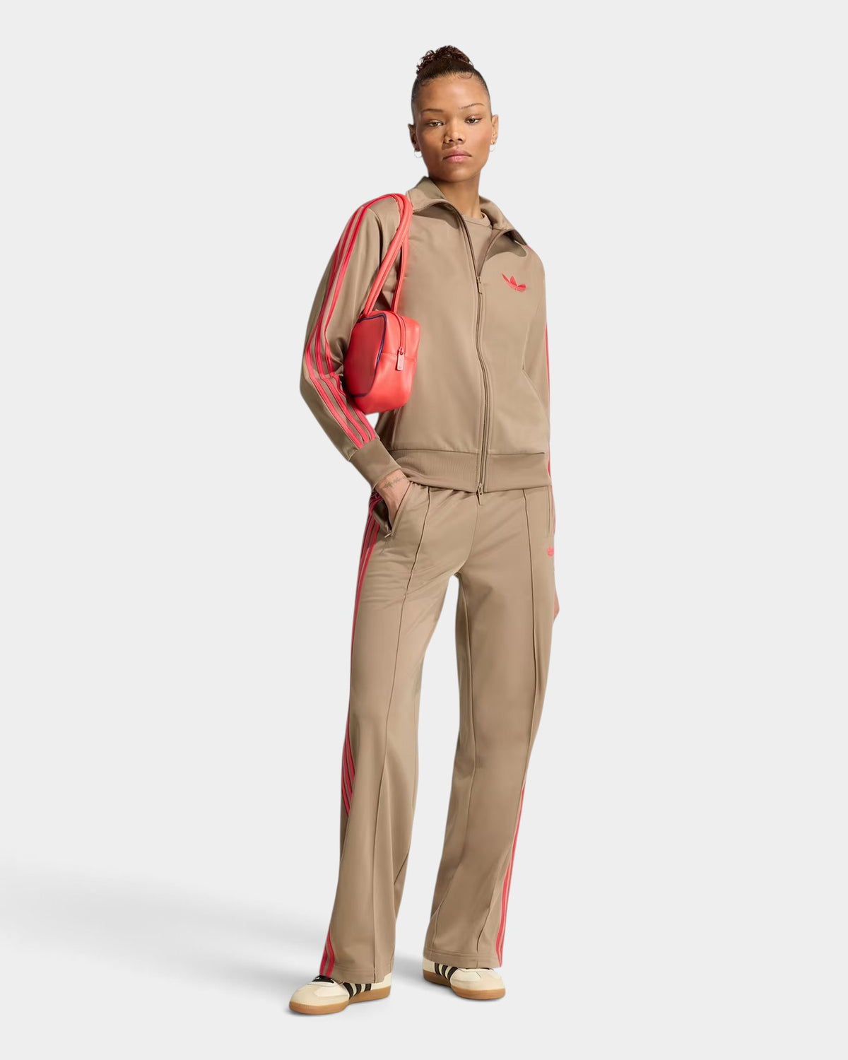 Model wearing Lockwood Avenue adidas Firebird loose track pants in beige with red 3-stripes and matching track jacket